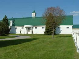 Broodmare Barn - Solid block construction with steel siding. 19 stalls (14 x 14') with raised office/observation room. Feed room. Vet examination area. Washroom. Loft storage. The stalls are 2